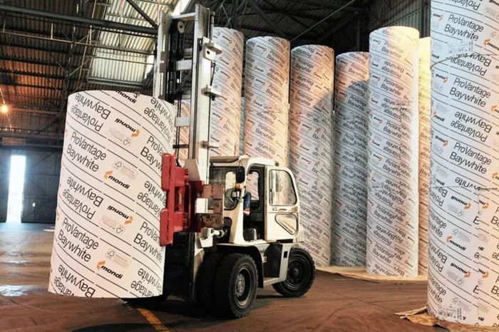 Forklift with clamp attachment lifting paper rolls