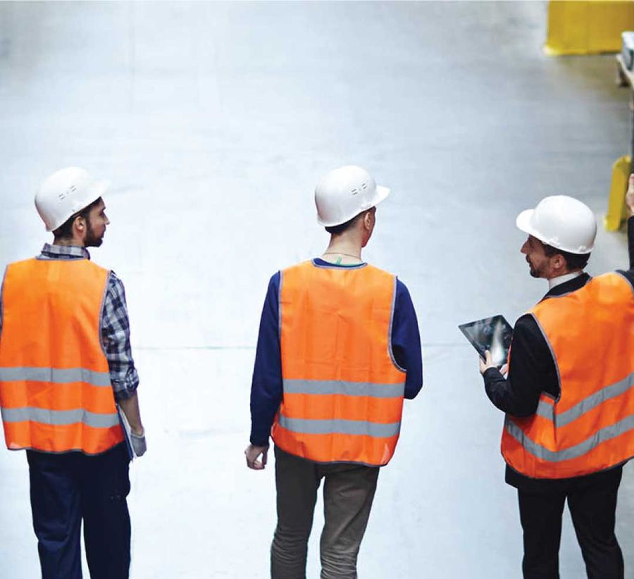 Supervisors in high-visibility vests on a warehouse floor